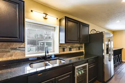 a kitchen with a sink and a refrigerator at Shop, Dine and Play Cincinnati Retreat! in Cincinnati