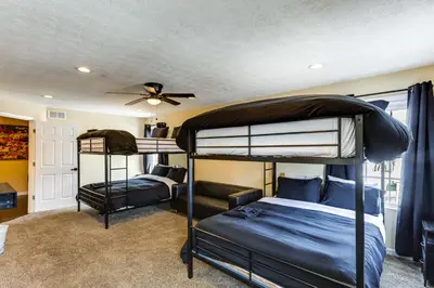 a bedroom with two bunk beds and a ceiling fan at Shop, Dine and Play Cincinnati Retreat! in Cincinnati