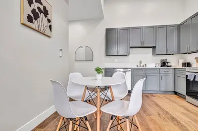 a kitchen with a white table and white chairs at The Pearl Hideaway Cozy West Side Gem Near DT in Cleveland