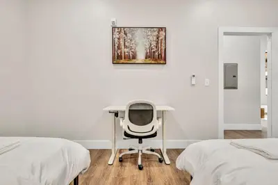 a desk and a chair in a room with two beds at The Pearl Hideaway Cozy West Side Gem Near DT in Cleveland