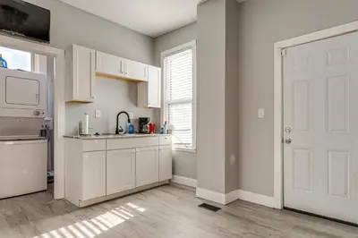 a kitchen with white cabinets and a white door at Walk to Trolley District Olde Towne East Retreat in Columbus