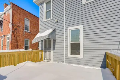 a gray house with a wooden fence in the snow at Walk to Trolley District Olde Towne East Retreat in Columbus