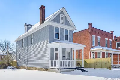 a gray house with a chimney and a brick building at Walk to Trolley District Olde Towne East Retreat in Columbus