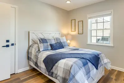 a bedroom with a bed with a blue and white comforter at Stay in the Heart of London! Walkable, Modern Home in London