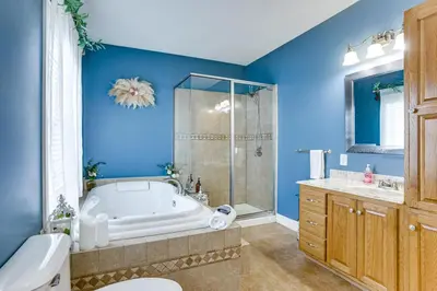 a blue bathroom with a tub and a shower at Family Home on 9 Acres! Climbing Wall and Gym in Thornville