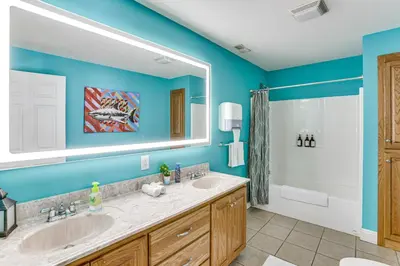 a bathroom with two sinks and a large mirror at Family Home on 9 Acres! Climbing Wall and Gym in Thornville