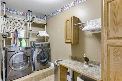 a small laundry room with a washer and dryer at Family Home on 9 Acres! Climbing Wall and Gym in Thornville