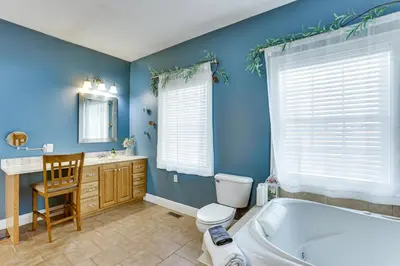 a bathroom with blue walls and a tub and a toilet at Family Home on 9 Acres! Climbing Wall and Gym in Thornville