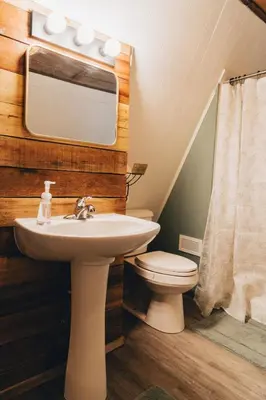 a bathroom with a sink and a toilet at The Rustic Triangle A-Frame in Perrysville