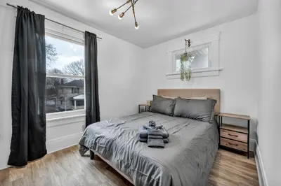 a bedroom with a large bed and a window at Modern Stylish Urban Haven 4 Bedroom 2 Bath - Dog Friendly in Akron