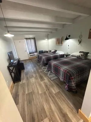 a bedroom with two beds and a television in it at Tecumseh Inn & Suites in Tecumseh