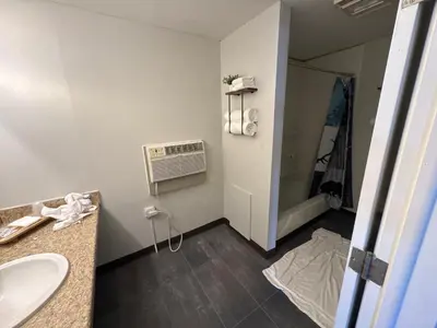a bathroom with a sink and a air conditioner at Tecumseh Inn & Suites in Tecumseh