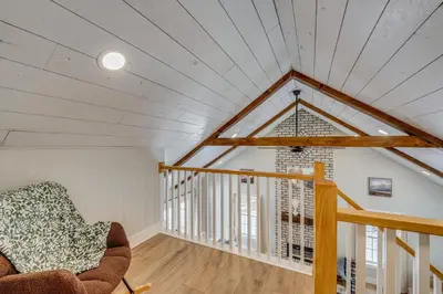 an attic room with a window and a chair at Willard Home On Working Farm with Water Views! in Willard