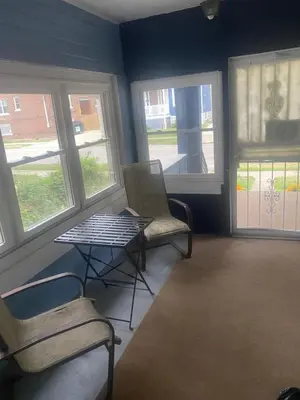 a room with two chairs and a table and windows at Rooms for Rent in Cleveland