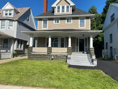 a house with a front porch and columns at Rooms for Rent in Cleveland