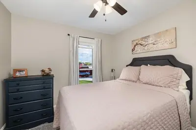 a bedroom with a bed and a ceiling fan at Historic Farmhouse with Pool & Barn in Mansfield