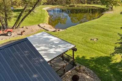 an overhead view of a building next to a pond at Historic Farmhouse with Pool & Barn in Mansfield