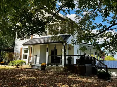 a white house with a black roof at Historic Farmhouse with Pool & Barn in Mansfield