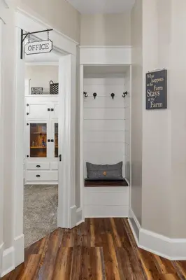 a hallway with white walls and a bench in a room at Historic Farmhouse with Pool & Barn in Mansfield