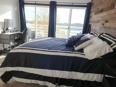 a bedroom with a bed with a desk and a window at Port Clinton Paradise- Waterfront 2 bedroom, Pool, Hot tub, Sauna, Fire pit in Port Clinton