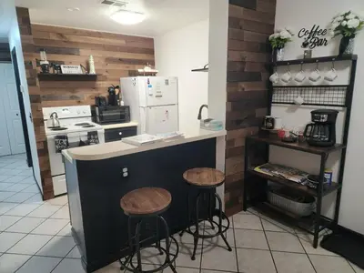 a kitchen with two stools and a counter with a refrigerator at Port Clinton Paradise- Waterfront 2 bedroom, Pool, Hot tub, Sauna, Fire pit in Port Clinton