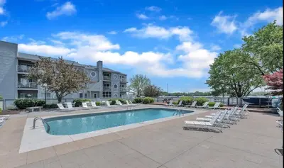 a swimming pool with lounge chairs and a building at Port Clinton Paradise- Waterfront 2 bedroom, Pool, Hot tub, Sauna, Fire pit in Port Clinton