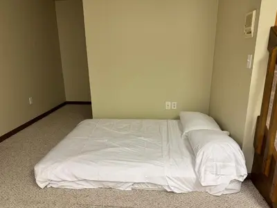a bed in a room with white sheets and pillows at Luxury 5BR Estate: Media Room & Golf | Sleeps 14 in Sylvania