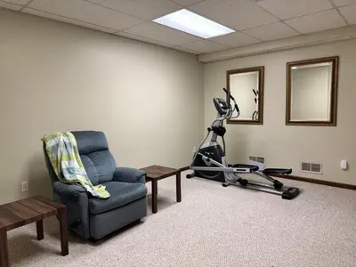 a waiting room with a chair and a treadmill at Luxury 5BR Estate: Media Room & Golf | Sleeps 14 in Sylvania