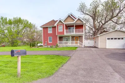 a red house with a driveway in front of it at 7 Mi to Cedar Point Retreat with Hot Tub and Gazebo in Huron