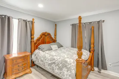 a bedroom with a wooden bed and a wooden dresser at 7 Mi to Cedar Point Retreat with Hot Tub and Gazebo in Huron