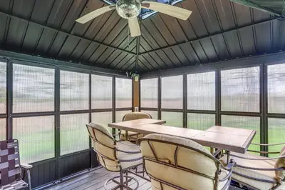 a dining room with a ceiling fan and a table and chairs at 7 Mi to Cedar Point Retreat with Hot Tub and Gazebo in Huron