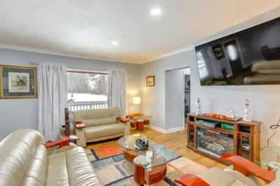 a living room with a couch and a table at 7 Mi to Cedar Point Retreat with Hot Tub and Gazebo in Huron