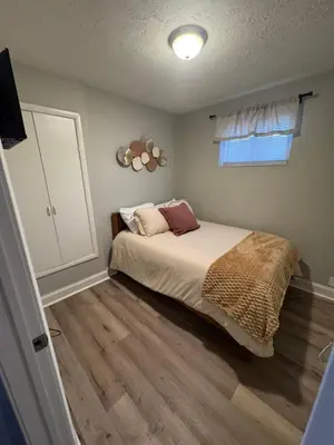 a bedroom with a bed and a window at The Cozy Cottonwood Cottage- Clintonville 3BRM Ranch in Columbus