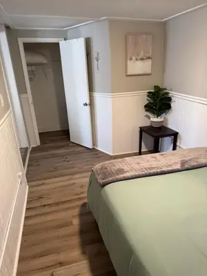 a bedroom with a bed and a plant on a table at The Cozy Cottonwood Cottage- Clintonville 3BRM Ranch in Columbus