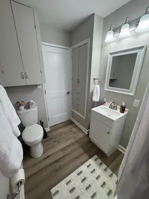 a bathroom with a white toilet and a sink at The Cozy Cottonwood Cottage- Clintonville 3BRM Ranch in Columbus