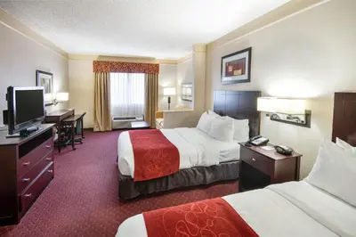 a hotel room with two beds and a desk at River Bluff Hotel and Conference Center in Mineralwells