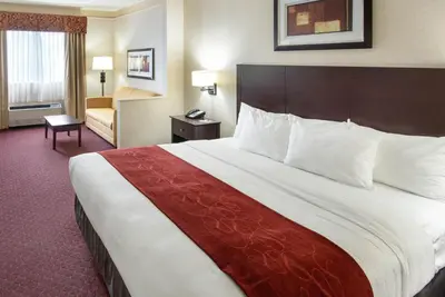 a hotel room with a large bed and a chair at River Bluff Hotel and Conference Center in Mineralwells