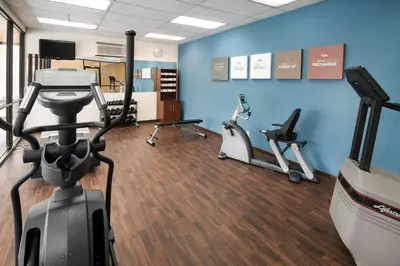 a gym with treadmills and exercise bikes in a room at River Bluff Hotel and Conference Center in Mineralwells