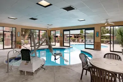 a swimming pool with a table and a chair and a table and a tablektop at River Bluff Hotel and Conference Center in Mineralwells