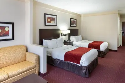a hotel room with two beds and a chair at River Bluff Hotel and Conference Center in Mineralwells