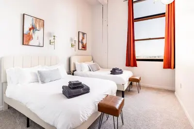 two beds in a room with red curtains at CLE Large Loft/Wolstein/Progressive/Playhouse/CSU in Cleveland