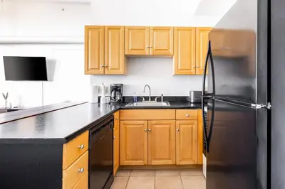 a kitchen with wooden cabinets and a stainless steel refrigerator at CLE Large Loft/Wolstein/Progressive/Playhouse/CSU in Cleveland
