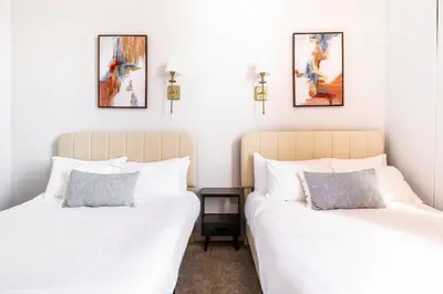 two beds in a room with white walls at CLE Large Loft/Wolstein/Progressive/Playhouse/CSU in Cleveland