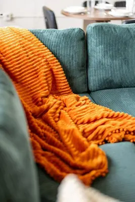 an orange blanket is laying on a couch at Downtown 2BR | Walk to Venues, Play house Square in Cleveland