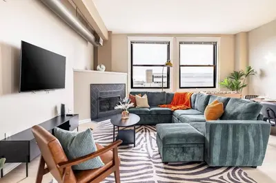 a living room with a blue couch and a fireplace at Downtown 2BR | Walk to Venues, Play house Square in Cleveland