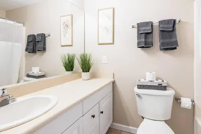 a bathroom with a sink and a toilet and a mirror at Downtown 2BR | Walk to Venues, Play house Square in Cleveland