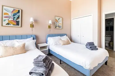 two beds in a small room with white and blue at Cleveland Loft/Wolstein/Progressive/Playhouse/CSU in Cleveland