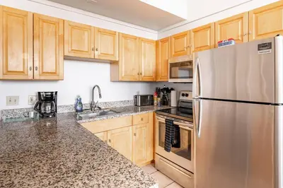 a kitchen with wooden cabinets and a stainless steel refrigerator at Cleveland Loft/Wolstein/Progressive/Playhouse/CSU in Cleveland