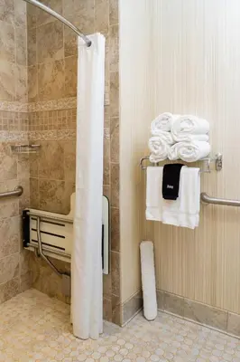 a bathroom with a shower with white towels at The Mount Vernon Grand Hotel in Mount Vernon