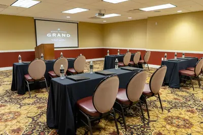 a conference room with tables and chairs and a screen at The Mount Vernon Grand Hotel in Mount Vernon